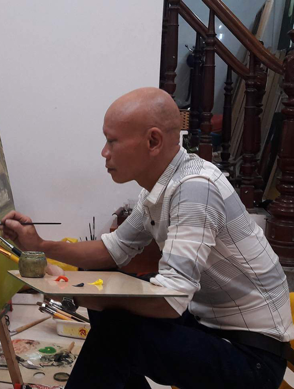 Le Huu Ich working on a painting